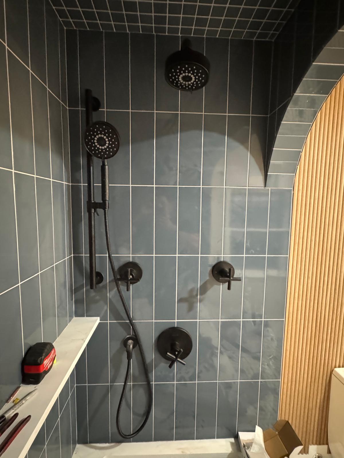 During — slate blue shower tile with arched opening and fluted wood accent