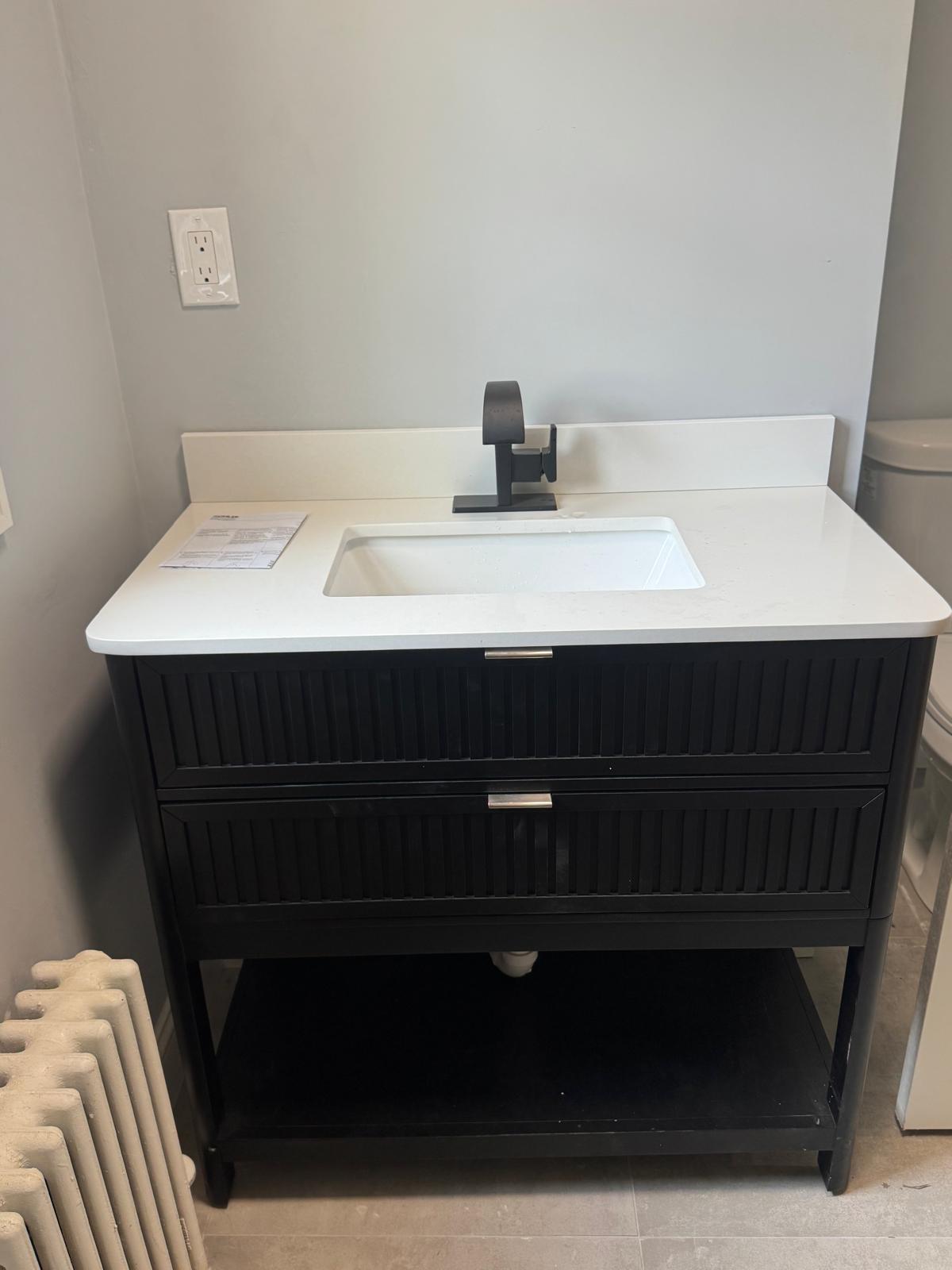Bathroom remodel — black vanity with quartz top and matte black faucet