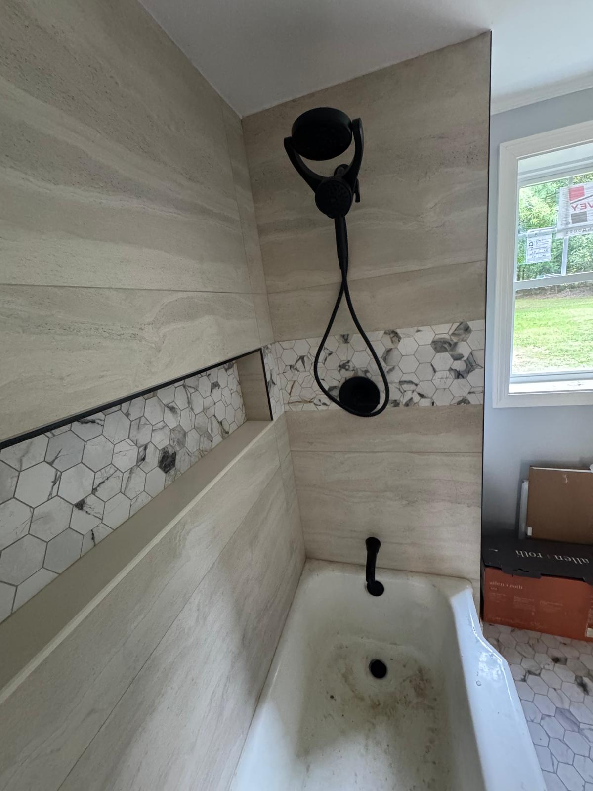 Tub and shower surround — marble hexagon niche with matte black trim