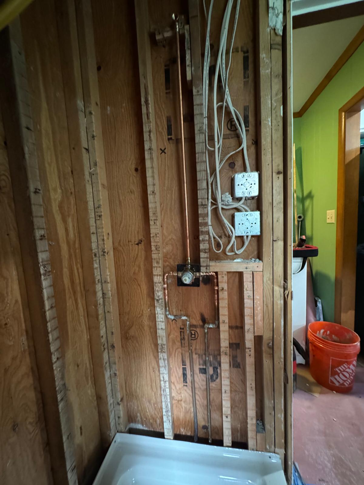 During — shower wall opened to the studs for new plumbing and wiring